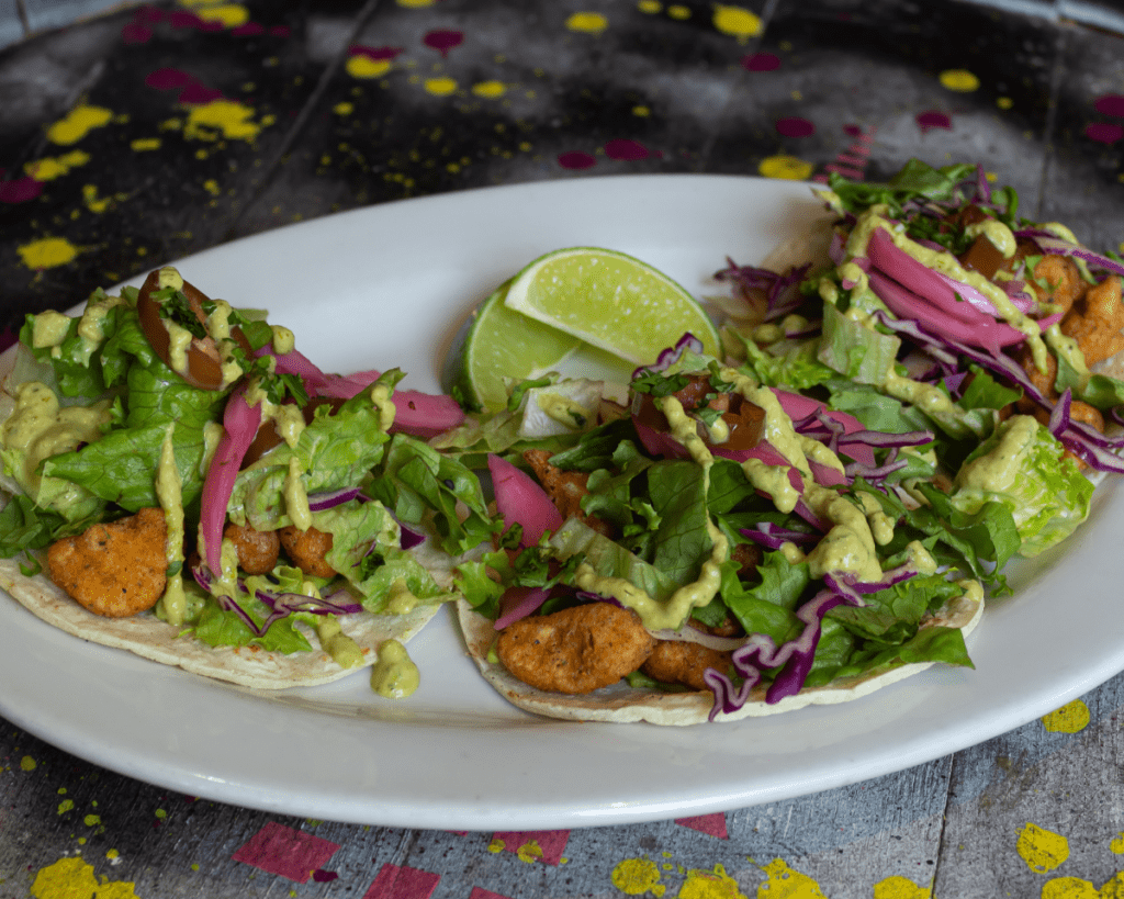 Plate of Fried Cauliflower Tacos topped with Poblano Ranch and Pickled Red Onions
